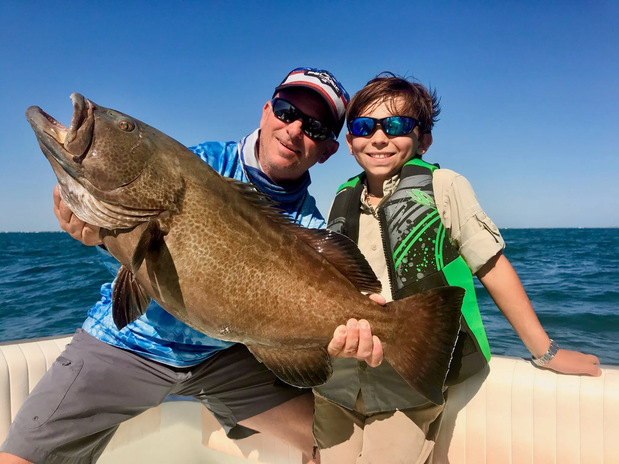 Angler and boy with a black grouper