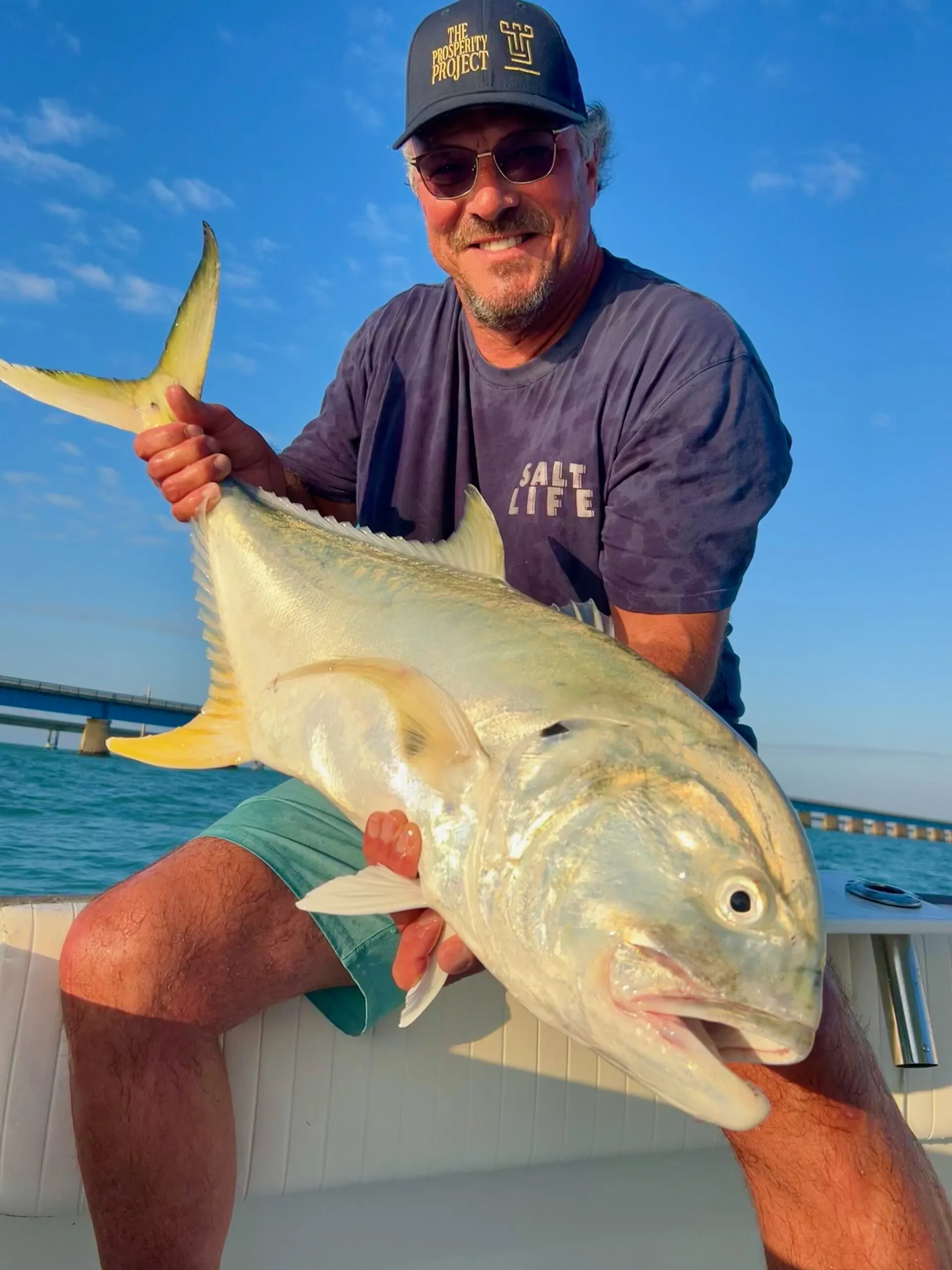 Angler with a jack crevalle by the bridge