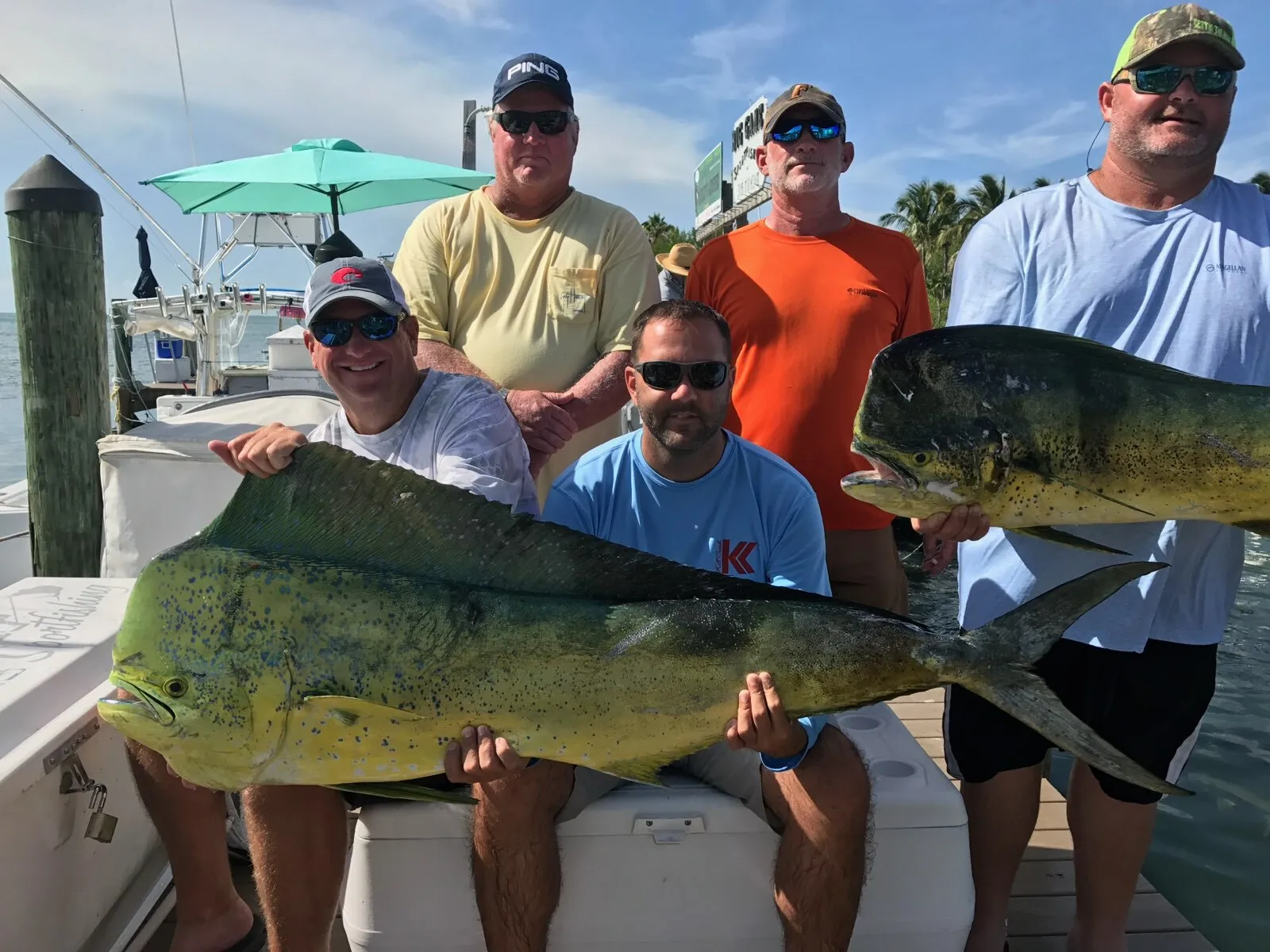 Five anglers with mahi at the dock