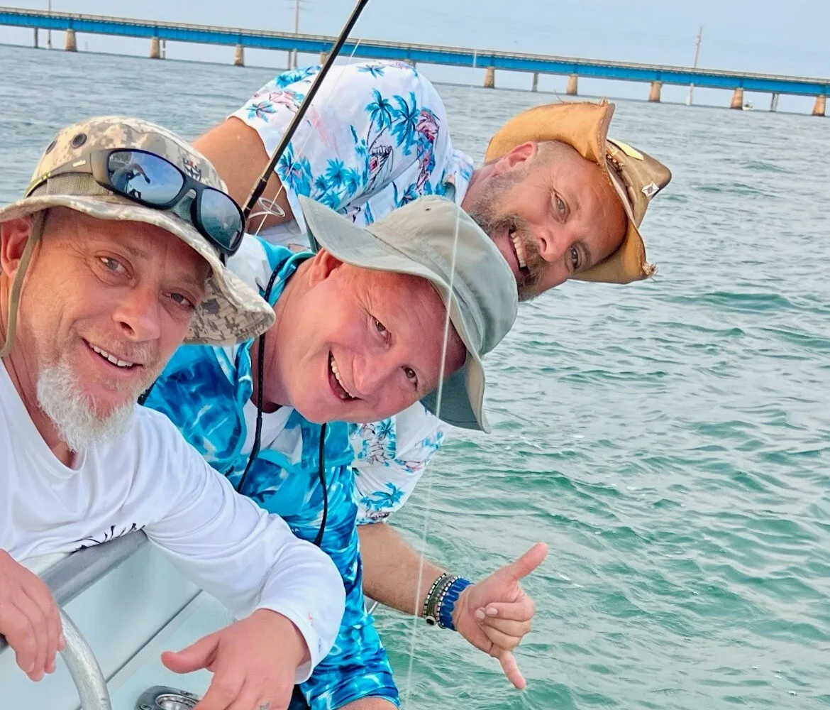 Three anglers pointing at their tarpon