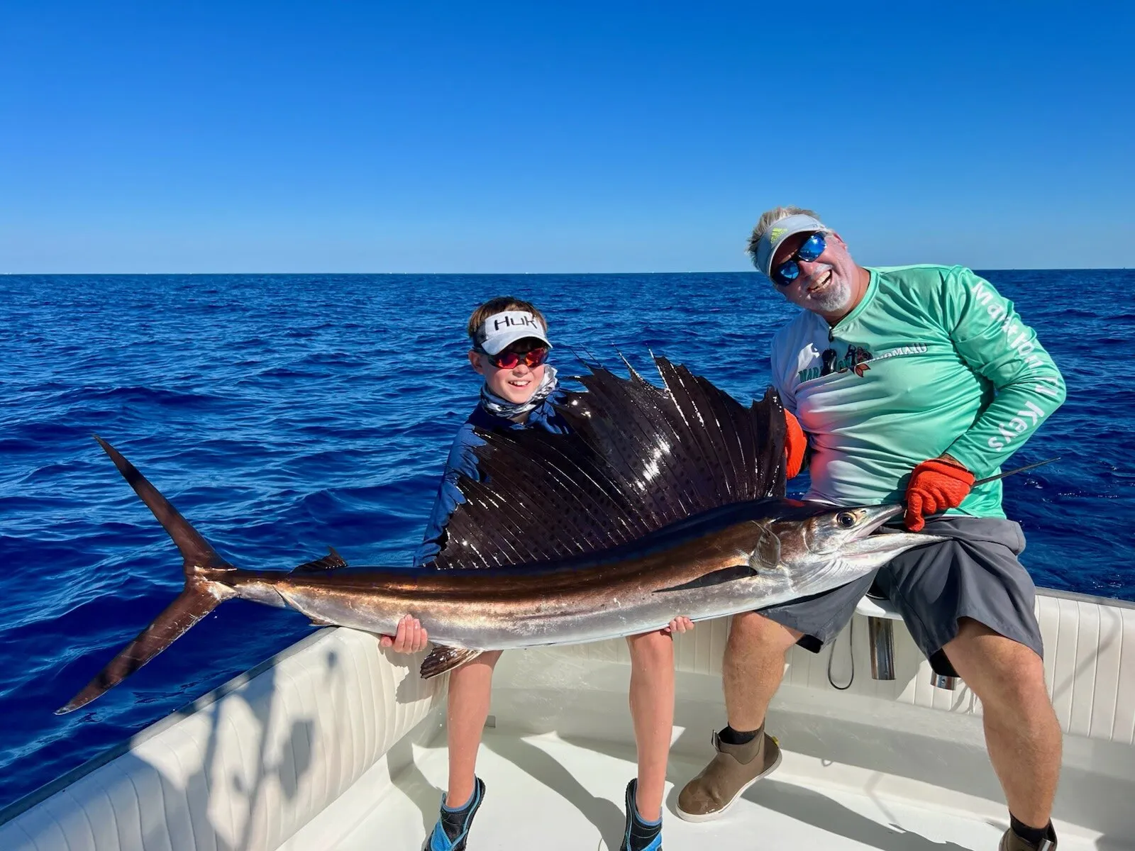 Two anglers with a sailfish at sea
