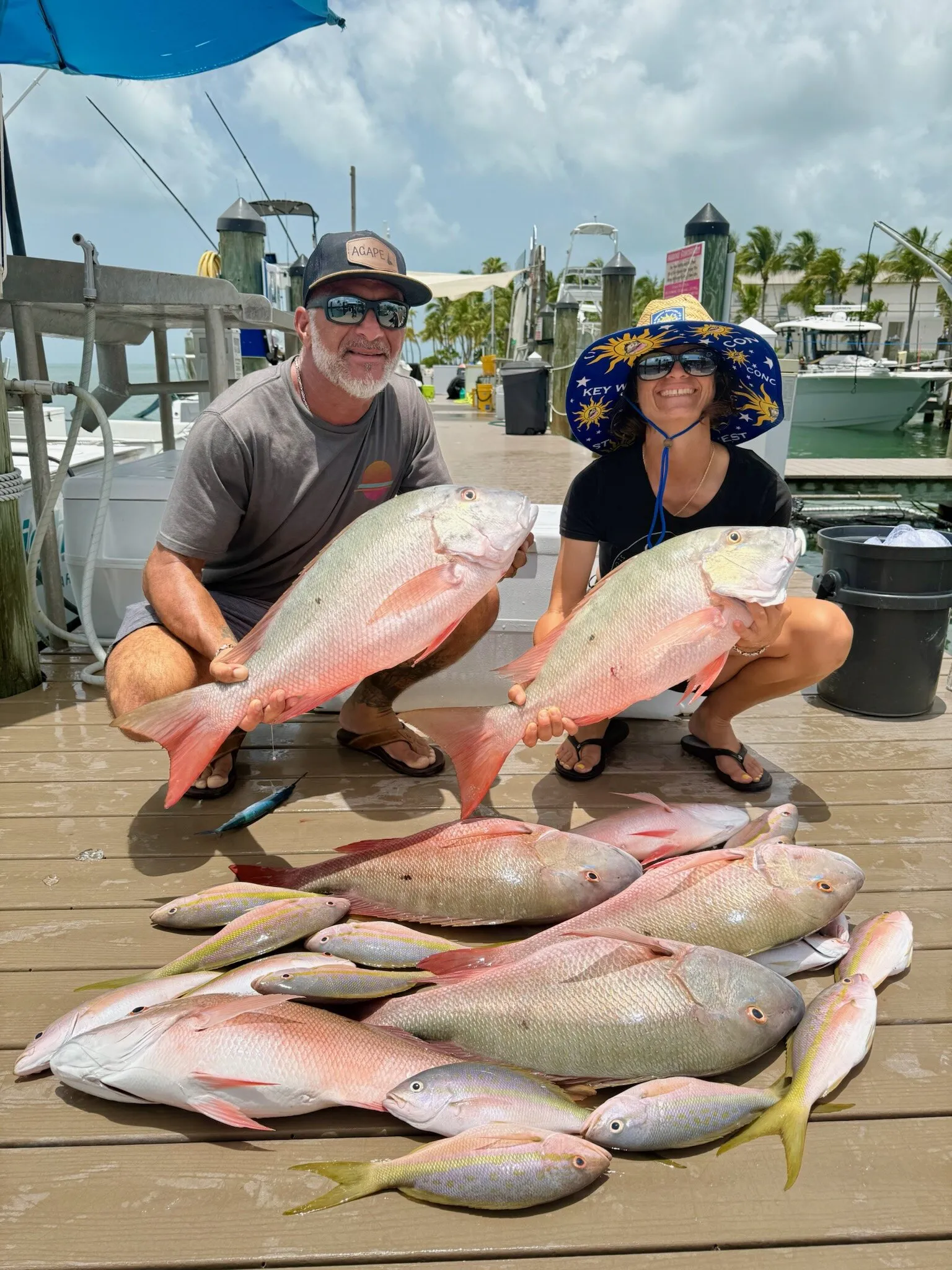 Two anglers with mutton snappers on the dock